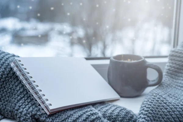 Boş defter ve çay üzerinde pencere pervazına, bir kış günü  