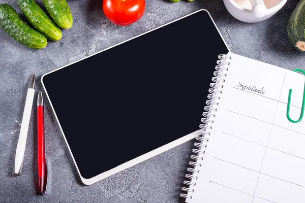 Notebook, Vegan menu and digital tablet on wooden tablet
