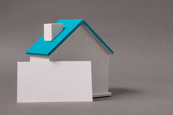 Casa de madera en miniatura, símbolo, con tarjeta de visita —  Fotos de Stock