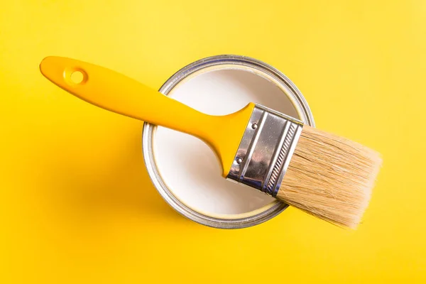 Lata de pintura blanca con vista superior del pincel sobre fondo amarillo . — Foto de Stock