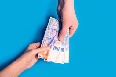 para, mavi zemin üzerine İsviçre para geçerken eller