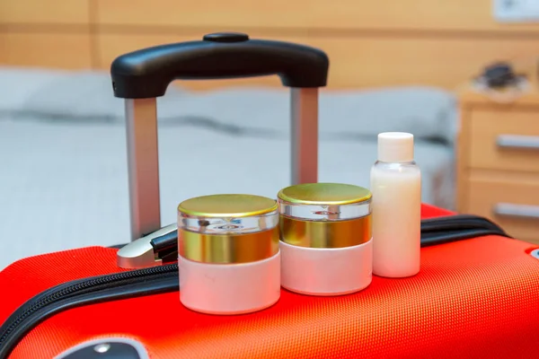 Pequeñas botellas de viaje en maleta naranja — Foto de Stock