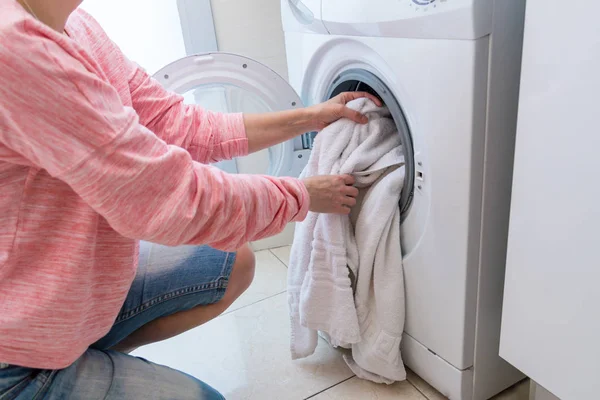 Mujer poniendo ropa sucia en la lavadora — Foto de Stock