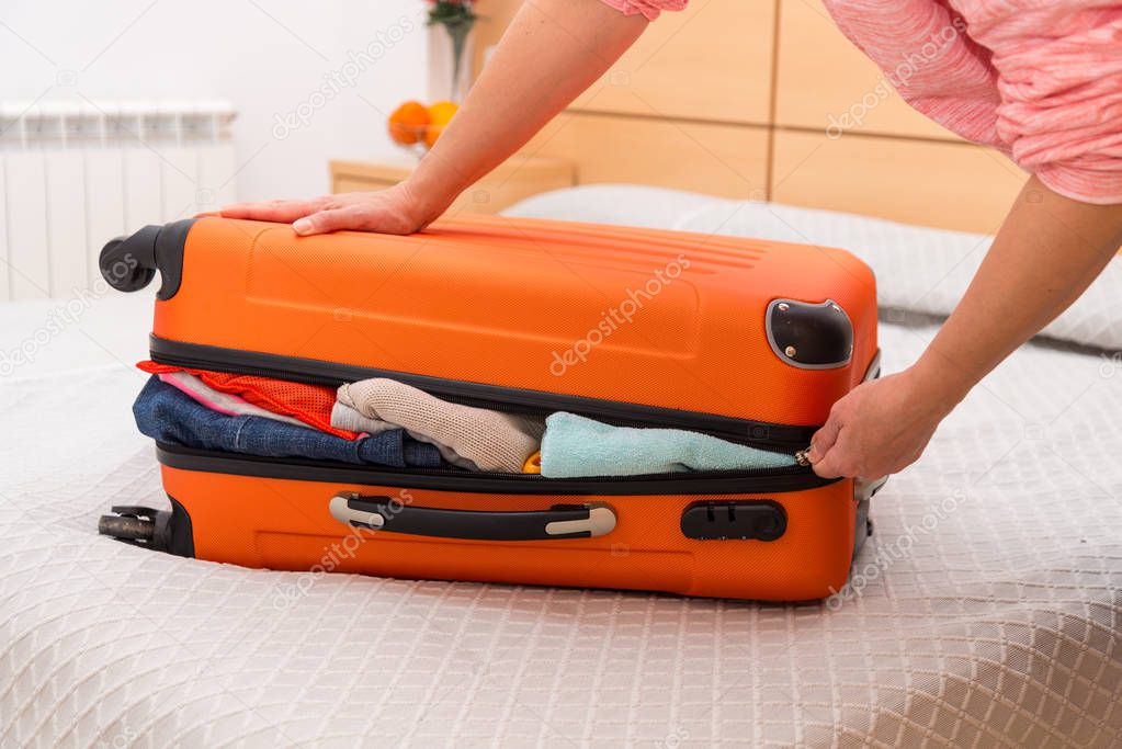 Woman having problem with closing suitcase