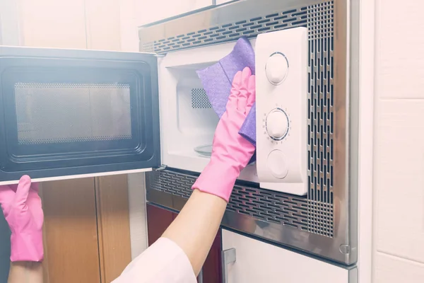 Le mani di donna puliscono il forno a microonde — Foto Stock