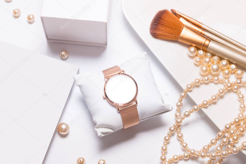 Beautiful watch, jewelry and cosmetic on woman table