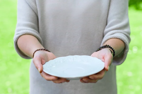 Asszony kezében tartja üres porcelán tányér — Stock Fotó