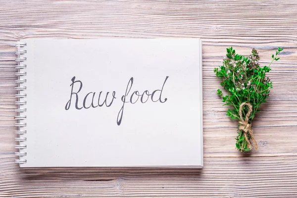 Letters Raw  Food on notebook on wood background