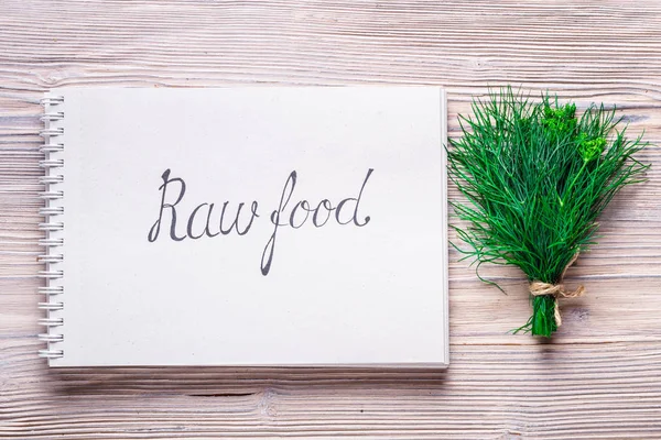 Letters Raw  Food on notebook on wood background