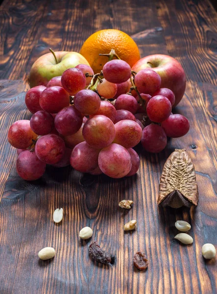 Raisins et fruits sur fond de vieux bois — Photo