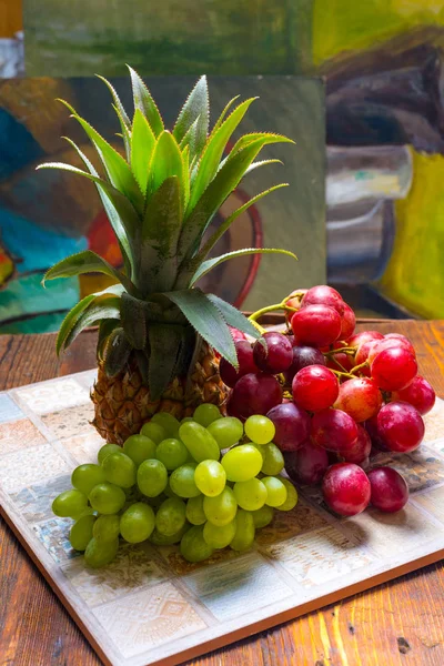 Hrozny, ananas na dřevěný stůl — Stock fotografie