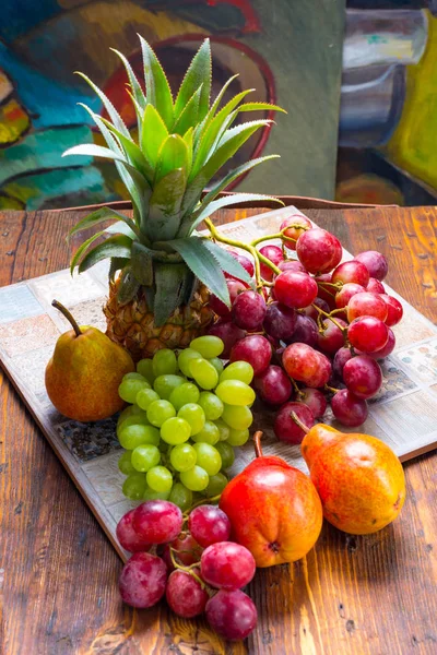 Hrozny, ananas a hrušky na dřevěný stůl — Stock fotografie