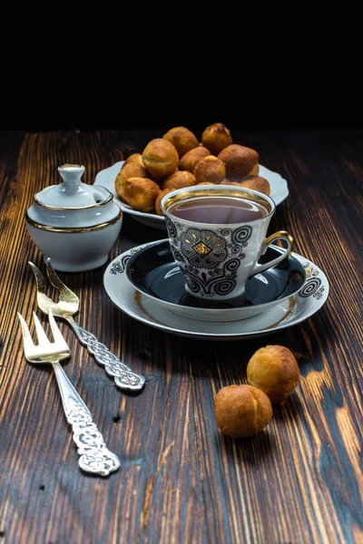 Cup of tea and donuts on wooden table — Stock Photo, Image