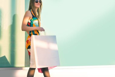 Alışveriş torbaları tutan genç bir kadın.