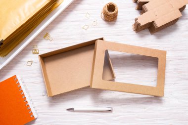 Brown carton box with transparent cover on wooden table