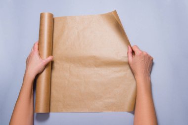 Kadın elleri gri arka planda kabartma kağıtlarını açıyor