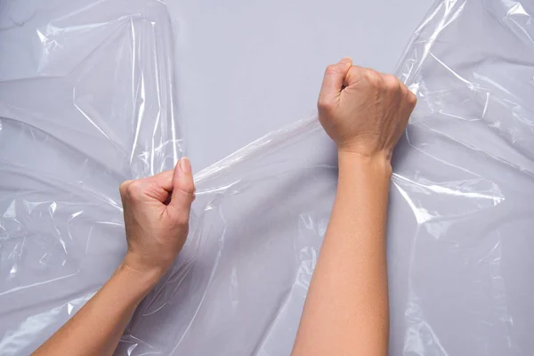 Vrouw handen trekken polyethyleen film — Stockfoto
