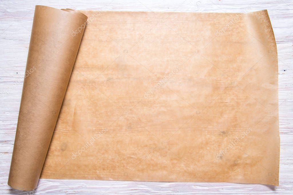 Roll of baking paper on wooden background