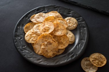 Siyah seramik kasede bir sürü pirinç cipsi. 