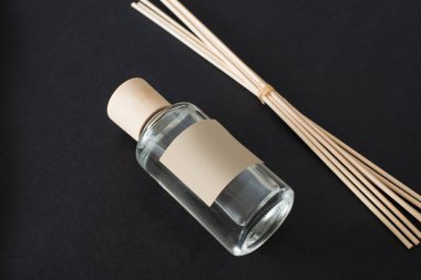 Kapalı alan aromalı siyah arka planda cam şişeli çubuklar.