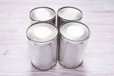 Ahşap masada metal teneke kutular var.