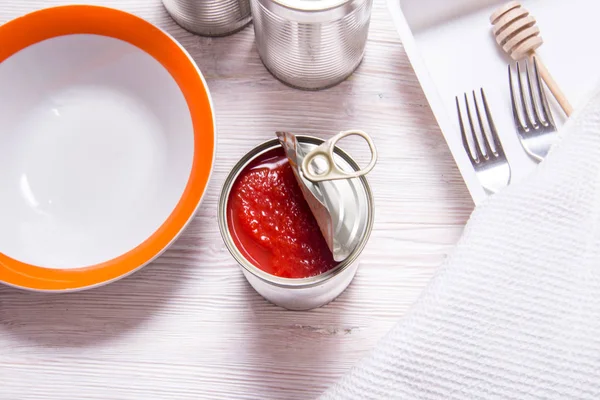 Geöffnete Blechdose mit Tomatenkonserven, auf hölzernem Küchentisch — Stockfoto