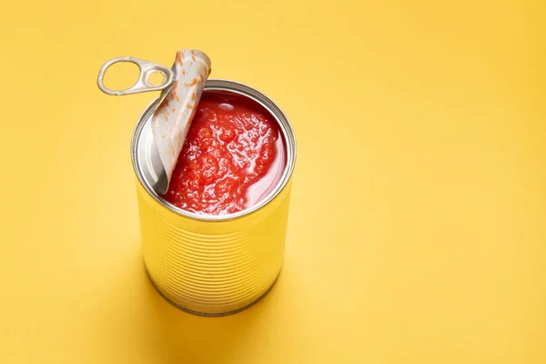 Otevřená plechovka s konzervovanými rajčaty, na žlutém pozadí — Stock fotografie
