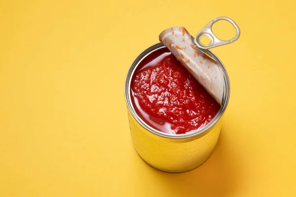 缶トマト缶を黄色の背景に開く — ストック写真