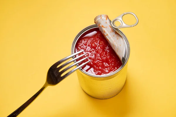 Opened tin can with canned tomatoes, on yellow background — 스톡 사진