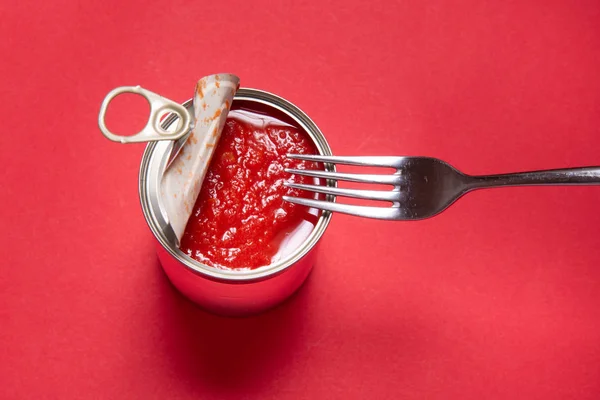 Lata abierta con tomates enlatados, sobre fondo rojo — Foto de Stock