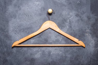 Boş ahşap kaplamalı elbise askısı gri taş duvarda asılı., 