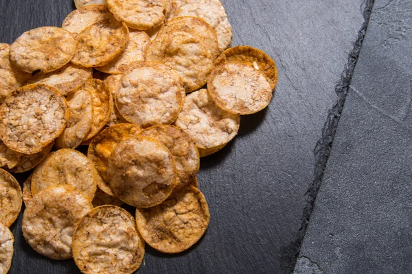 Ovanifrån hög med ekologiska, krispiga, bakade, fullkornsris chips — Stockfoto