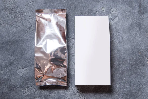 Foil package bag and white carton box on dark grey background