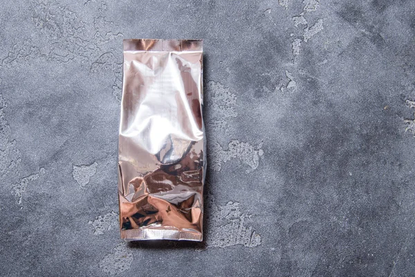 Foil package bag for food on dark grey background, copy space