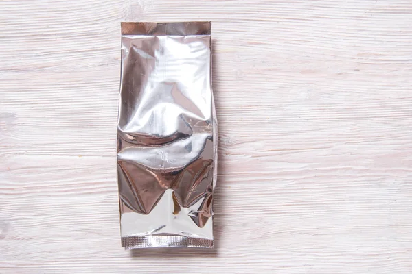 Foil package bag for food on white wood background — 스톡 사진