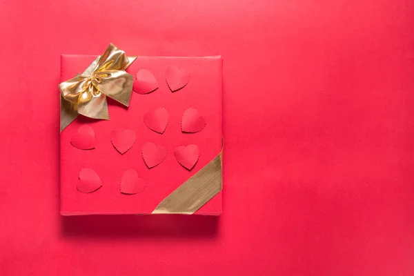 Piros ajándék doboz arany szalag piros háttér, másolás helyet — Stock Fotó