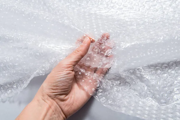 Hand holding packaging material, bubble film