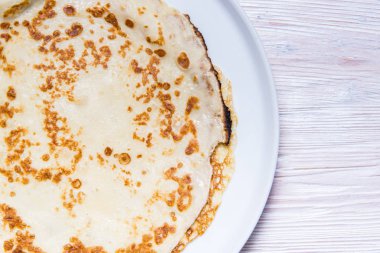 Porselen tabakta ve ahşap masada kızarmış krep.