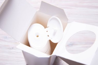 Üst manzara, karton Cox 'un içinde beyaz krema şişesi, ahşap kutu.