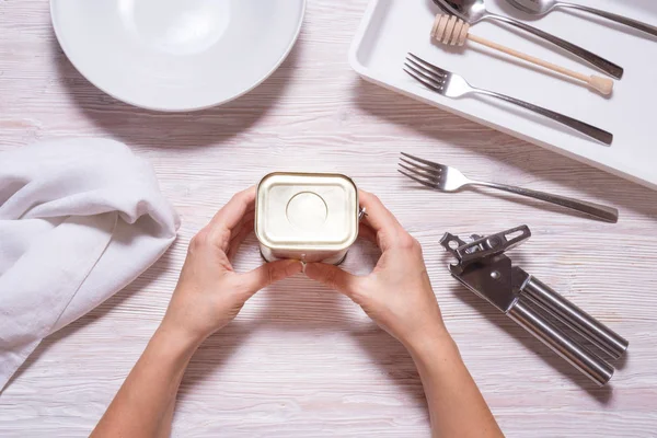 Las manos femeninas pueden abrir estaño con carne de cordero, mesa de cocina de primera vista. — Foto de Stock