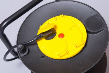 Siyah elektrik uzatma kablosu dört çoraplı bir makarada.