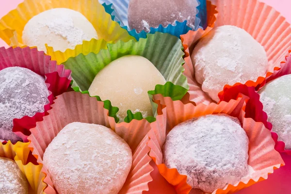 Πολλά mochi επιδόρπιο σε χάρτινα φλιτζάνια σε ροζ φόντο — Φωτογραφία Αρχείου