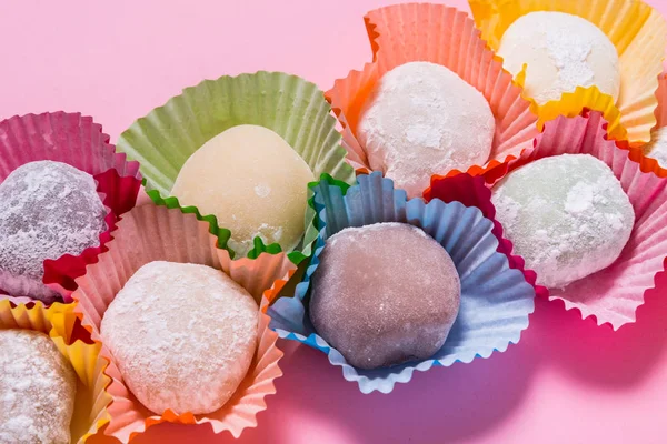 Wiele mochi deser w papierowych filiżanek na różowym tle — Zdjęcie stockowe