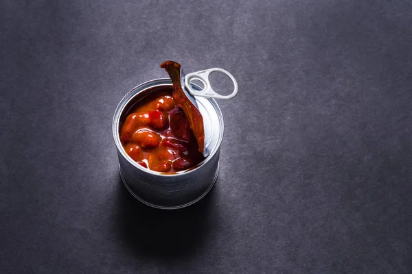 Puszka z puszką, gorąca fasola chili w puszce na czarnym tle — Zdjęcie stockowe