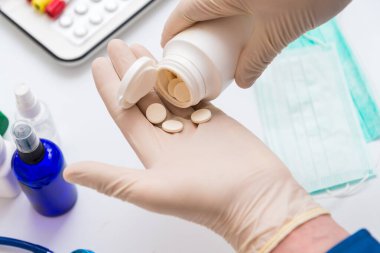 Elinde haplar, önleme ve koronavirüs tedavisi tutan bir adam.