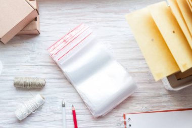 Ahşap ofis masasında bir sürü plastik zip kilit, küçük online otobüs.