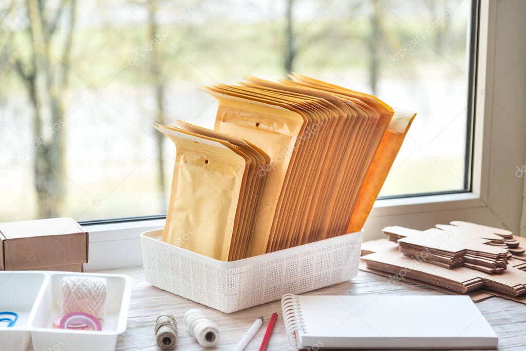 Brown postal envelopes on wooden office desk, working area
