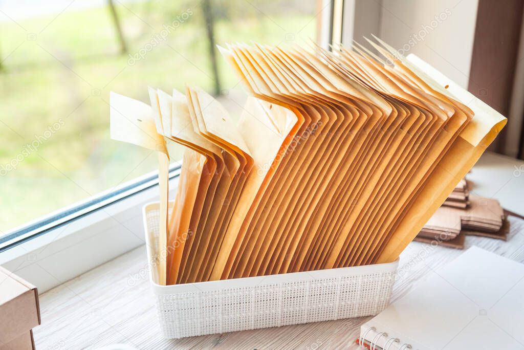 Brown postal envelopes on wooden office desk, working area