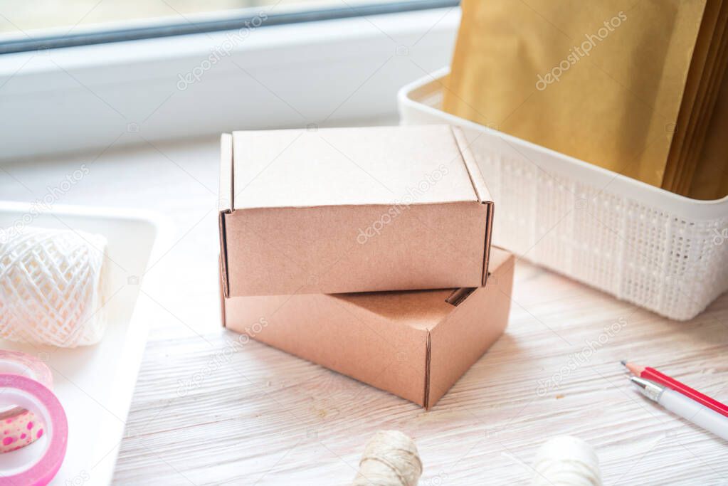 Brown postal carton box on wooden office desk, working area