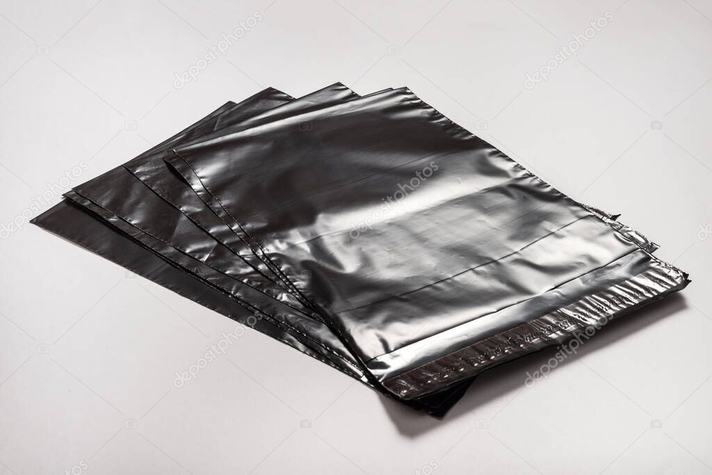 Set of black polythene envelopes on grey background